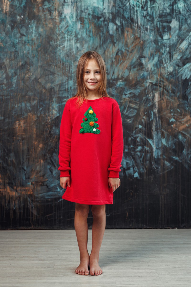 Girl's red dress with a decorated Christmas tree