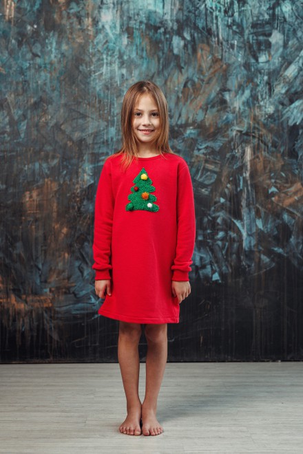 Girl's red dress with a decorated Christmas tree