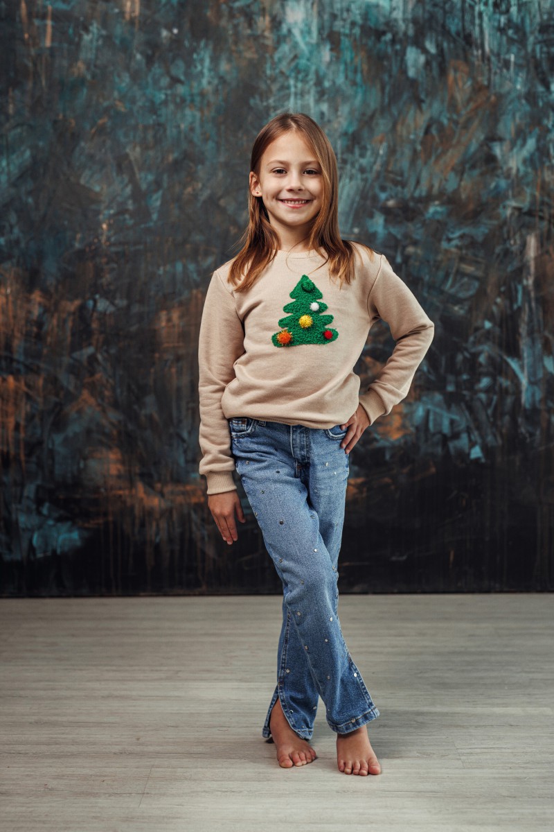 Girl's sand Christmas jumper with a decorated Christmas tree