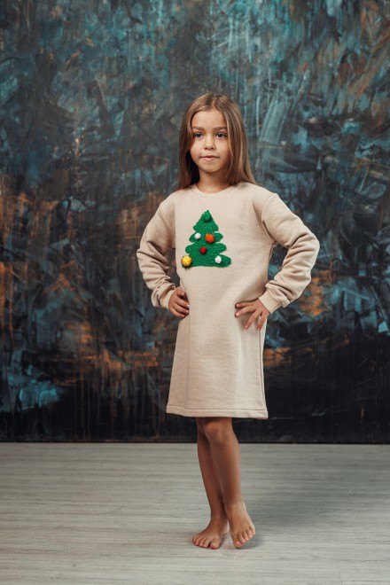 Girl's sand dress with a decorated Christmas tree